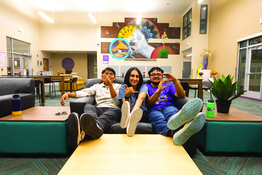 Three students sitting on couch in housing