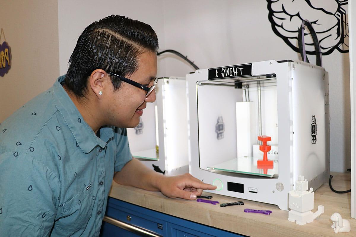 SJC Student working with a 3-D printer