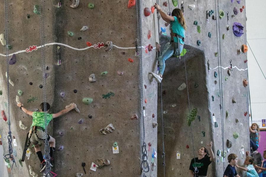 Three Kids Kollege students climbing on the Indoor Rock Climbing wall at HHPC